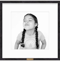 a black and white photo of a little girl with braids